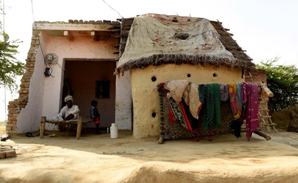 Sixty year-old villager Ram Kishore sits beneath a newly installed electricity meter at his home in the village of Anandpur. (AFP Photo)