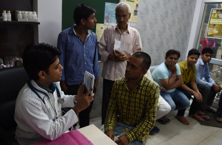 Doctor uses a tablet device to take a picture of a patient for his record in New Delhi.