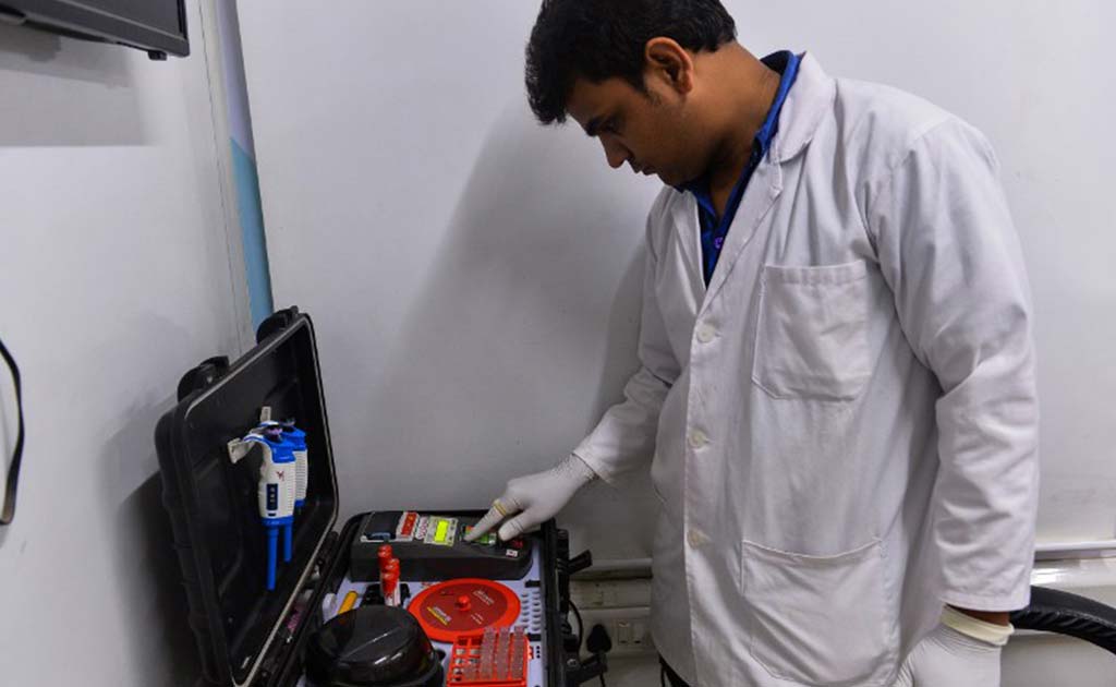 A doctor checks vialls of blood at the clinic in Mr Lal's neighbourhood in New Delhi.