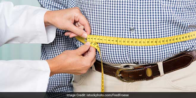 Measuring abdominal fat using a measuring tape.