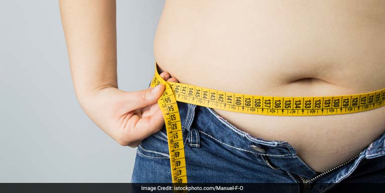 skinny girl measures her waistline after the weight loss diet with a yellow  flexible measuring tape Stock Photo